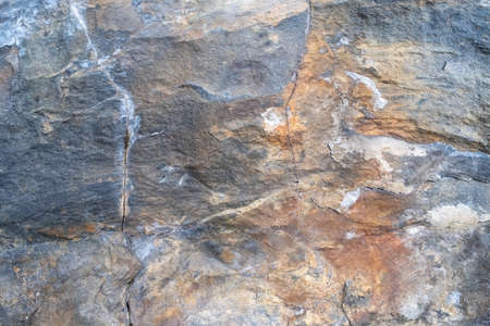 Multicolored rock wall. Stone textured surface close-up. Copy space. Abstract natural background.の写真素材