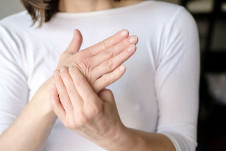 The woman experiences pain in her arm and massages her sore palm.の写真素材