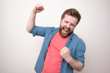 Cheerful, happy man, he laughs and makes a joyful hand gesture. Winning the lottery. Positive emotions. White background.の写真素材