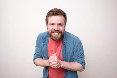Happy bearded Caucasian man in casual clothes smiling and looking friendly. White background.の写真素材