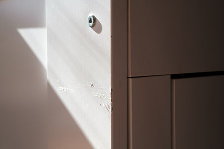 Scratched paint on a white couch, exposed to sunlight. Spoiled furniture. Close-up.の写真素材