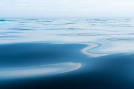 Calm, clear lake on the horizon with blue sky, on a summer day. Bottom view.の写真素材