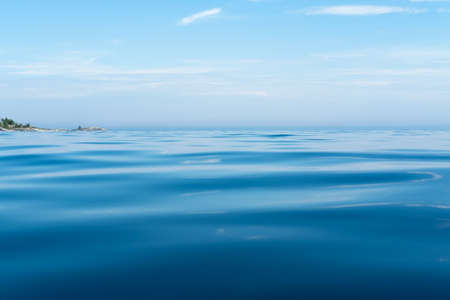 Clear lake on the horizon with sky and rocks, on a summer day. Bottom view.の写真素材