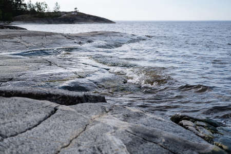 Beautiful summer landscape. Rocky coast, lake and horizon with blue sky.の写真素材