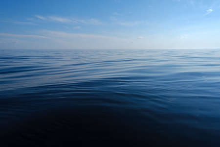 Quiet, clean lake on the horizon with blue sky and clouds. Beautiful wallpaper. Bottom view.の写真素材