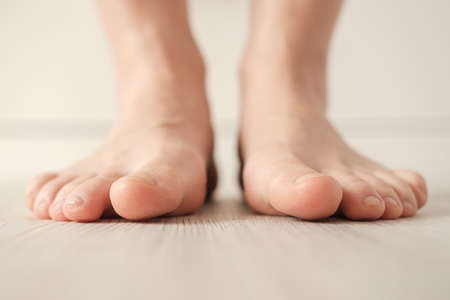 Barefoot female feet stand on the floor on a white background. Bottom view.の写真素材
