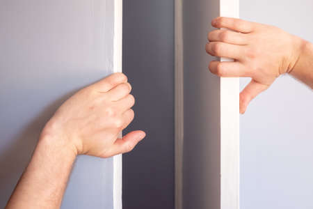 Male hands open the closet door in the room.の写真素材