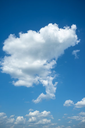 Fluffy white clouds and blue sky on a sunny summer day. Background.の写真素材