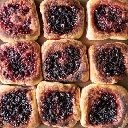 Delicious, appetizing hot pies with berry filling, cooked in a Russian oven, close-up. Hearty snack. Traditional cuisine.の写真素材
