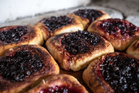 Delicious, mouth-watering homemade pies with berry filling, cooked in a Russian oven. Hearty, hot snack. Traditional cuisine.の写真素材