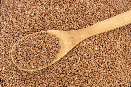 Wooden spoon in a heap of buckwheat. Healthy food and lifestyle. Copy space. Top view.の写真素材
