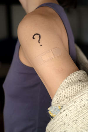 Female shoulder with drawn question mark and bandage after  vaccination. Vaccine selection concept.の写真素材