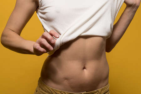Woman bared her belly with a scar obtained as a result of an an appendectomy, she is not ashamed of her flaw and feels confident.の写真素材