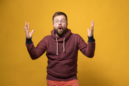 Caucasian bearded man in amazement, he makes a gesture with his hands in surprise or shows the size of something.の写真素材
