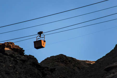 Silhouette of an old cable car and trolley for coal mining, at sunset, against a sky. Energy crisis concept.の写真素材