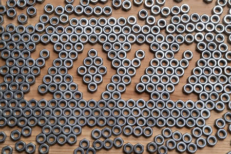 New Year 2022 is casually lined with metal nuts on a wooden table. Top view.の写真素材