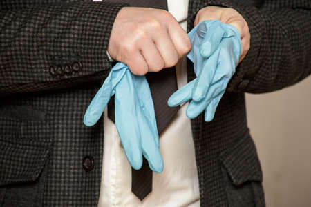 Man puts on protective medical rubber gloves on his hands. Close-up.の写真素材