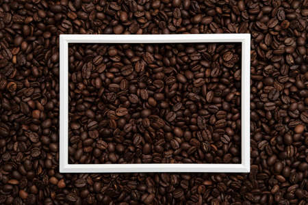 White frame on roasted coffee beans. Beautiful background. Copy space. Top view.の写真素材