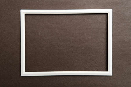 White rectangular blank frame on brown textured background. Copy space. Top view.の写真素材