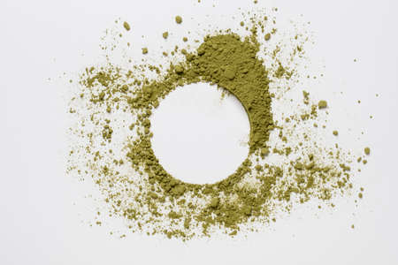Circle made of green powder scattered on a white background, with a place for text. Copy space. Bright dry paint. Top view.の写真素材