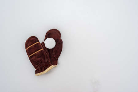 Snowball on brown suede warm mittens, in the snow. Winter active games and entertainment. Copy space.の写真素材