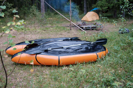 Two packrafts lie to dry in the camp, against the backdrop of a tent, in the forest, in summer. Active lifestyle concept.の写真素材