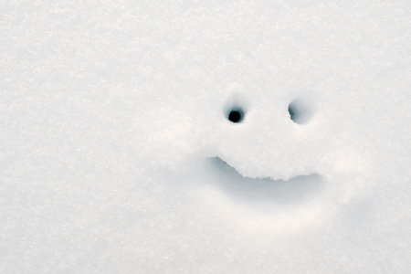 Smiley painted on the snow on a winter day. Copy space. Top view.の写真素材