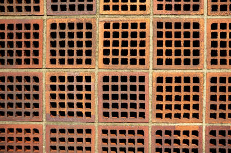 Red brick wall with square holes. Copy space. Abstract background.