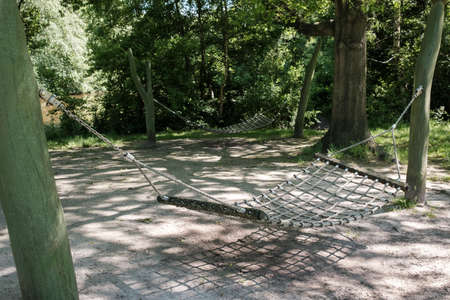 Rope wicker hammock hangs on the playground in the park, against the background of trees.の写真素材