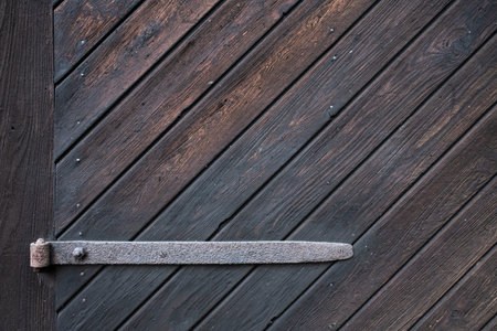 Vintage wooden door with iron hinge, can be used as a textured background. Copy space.