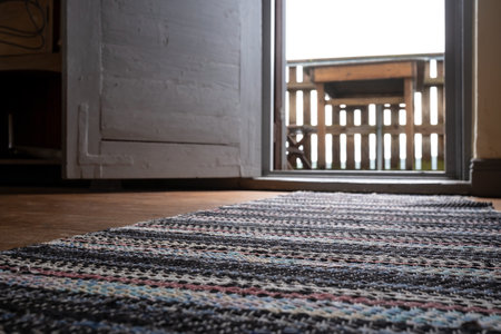 Open white door with access to the balcony, against a blurred background table.の写真素材