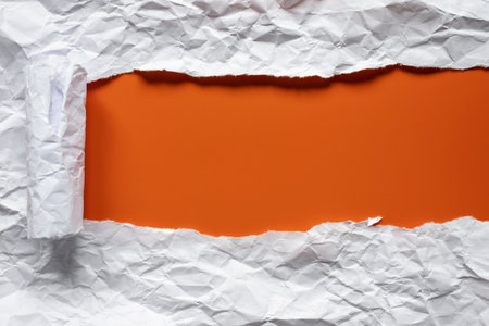 Torn sheet of white crumpled paper, folded into a roll, on a red background with a place for an inscription. Copy space. Top view.の写真素材