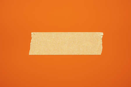 Beige paper adhesive tape on a red background. Copy space. Close-up.の写真素材