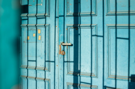 Old wooden door with a shadow pattern on its surface, outdoors.