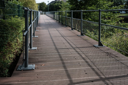 Wooden walkway with metal railings for a safe walk in the park.の写真素材