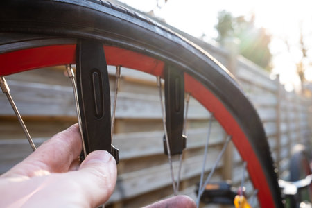 Cyclists hand removes the tire with a special lever tool. Repairing a punctured bicycle wheel.の写真素材
