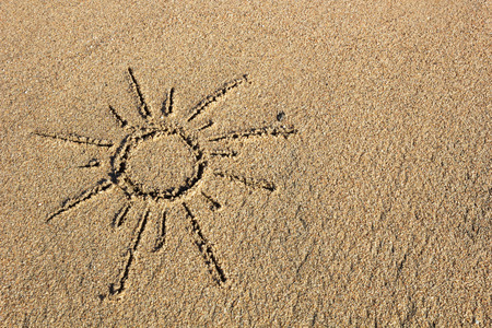 Draw the outline of sun on the sandの写真素材