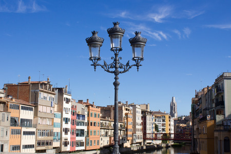 Girona, Spain - September 15, 2016: view on Girona riverside. Antique lantern on the bridgeのeditorial素材