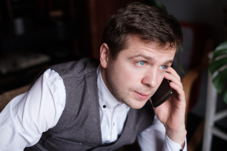 A young man listens attentively to what they say on the phoneの写真素材