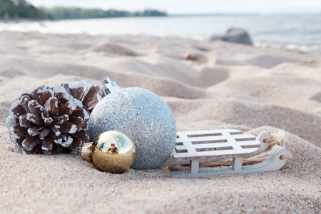Christmas decoration balls on a sandy beach. Have a holiday on winter holidaysの写真素材