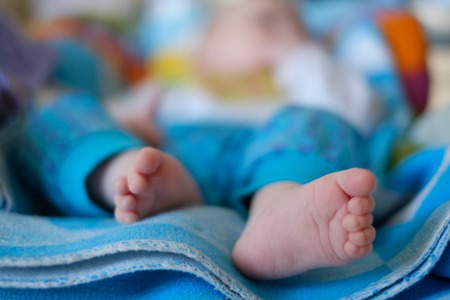 Newborn baby feet on a blue towelの写真素材
