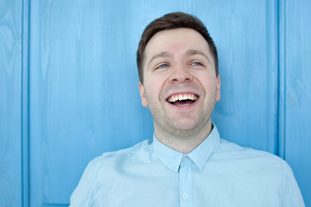 Caucasian man in blue shirt smiling happiness carefree emotional expression conceptの写真素材