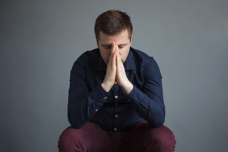 Handsome depressed man on grey background.の写真素材