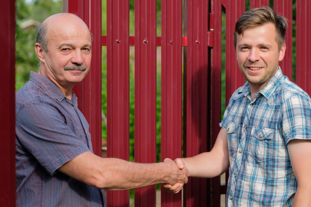 two farmers shaking hands and takling to each otherの写真素材
