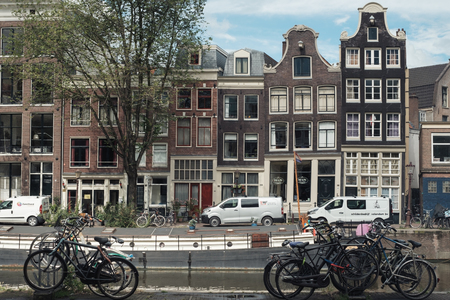 AMSTERDAM, HOLLAND - July 24, 2017:embankment of old Amsterdam with parked bicycles and dancing housesのeditorial素材