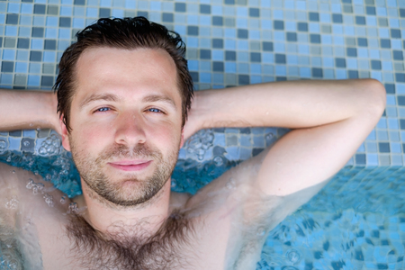 Content caucasian man in a swimming pool.