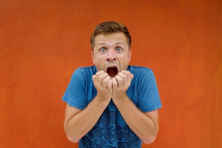 Anxious man is shocked and opening his mouth in surpriseの写真素材
