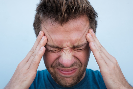 Portrait of caucasian man having a headache close up.の写真素材