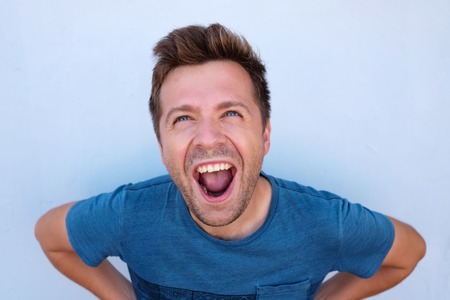 Portrait of a mature caucasian man screaming because of positive news.の写真素材