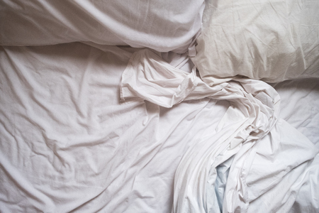 White Bed maid-up with wrinkled bed sheets after sexual night